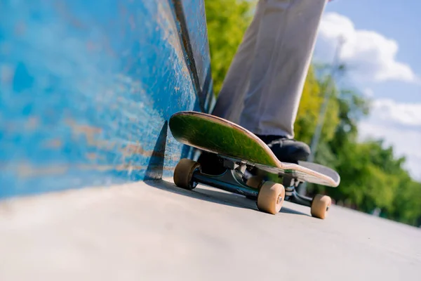スケートボーダーの脚をスケートボードでクローズアップし 市内のスケートパークでトリックの間を休む — ストック写真