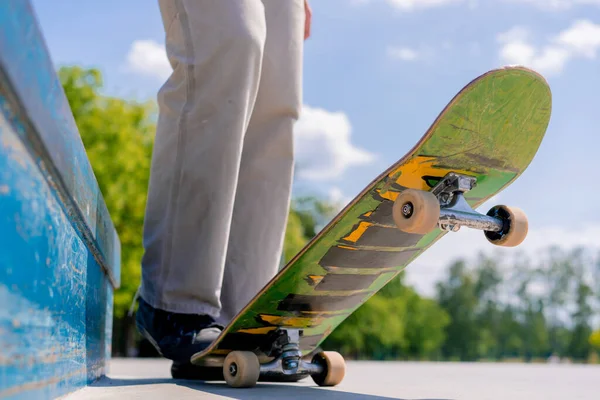 スケートボーダーの脚をスケートボードでクローズアップし 市内のスケートパークでトリックの間を休む — ストック写真