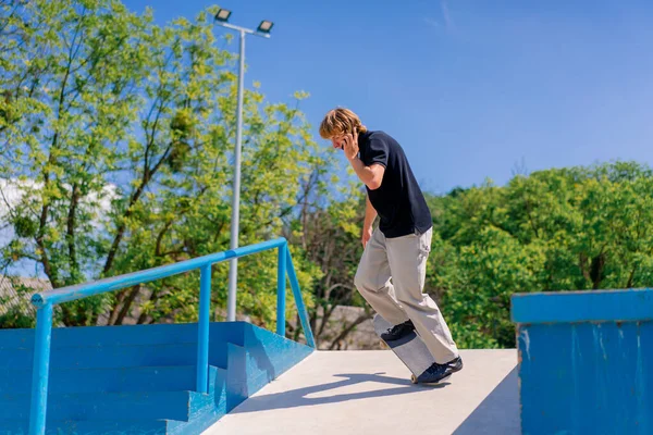 Mladý Kluk Skateboardista Dlouhými Vlasy Skateboarding Městě Skatepark Mluvit Telefonu — Stock fotografie