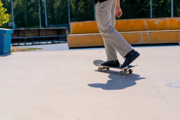 年轻男子滑板运动员在城市滑板公园周围滑板旁边的特技特写特写 — 图库照片
