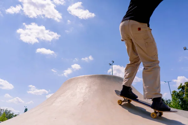 若い男のスケーターは 都市スケートパークの空と雲の背景に対してスケートプールの端にスタントを行います — ストック写真