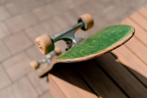 公園のベンチの隣に立っているスケートボードのクローズアップ アドレナリン彫刻とスケートボードのための愛の概念 — ストック写真
