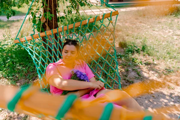 Chica Joven Acostada Hamaca Parque Descansando Patinar Sosteniendo Ramo Flores — Foto de Stock