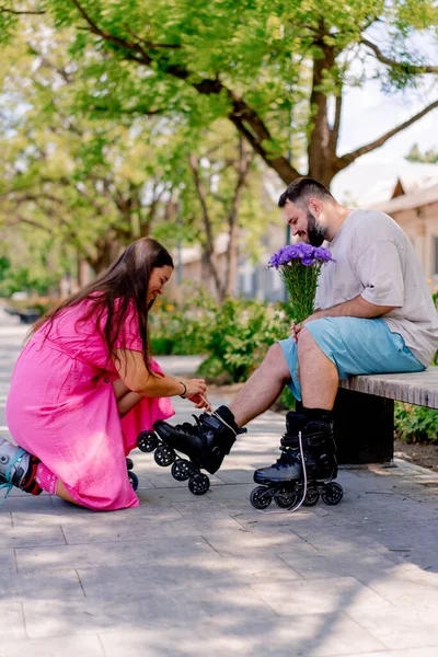 若いカップルガールは デート中に花束を保持している公園のベンチに座っている男を助け サイズモデル — ストック写真