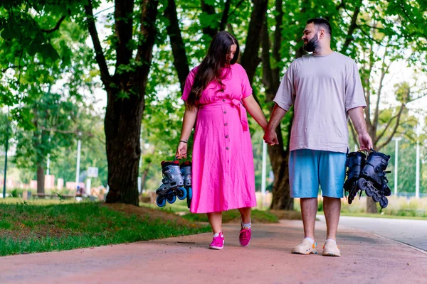 Young Couple Walks Park While Date Holding Hands Holding Rollerblades — Stock Photo, Image