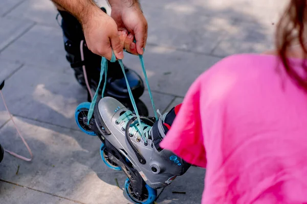 Young Couple Guy Helps Girl Put Rollerblades Who Sitting Bench — Stock Photo, Image