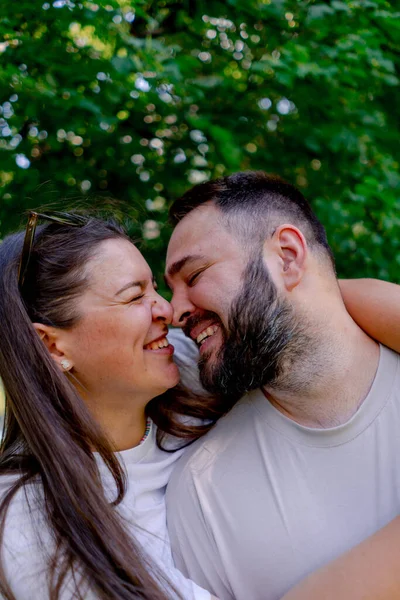 一对年轻夫妇的画像在一个公园加一个尺寸模型的背景下 他们站在一个拥抱和亲吻的地方 — 图库照片