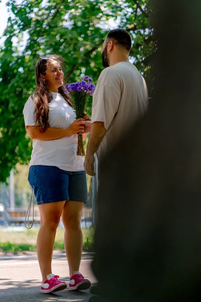Fiatal Pár Vidám Srác Virágot Lánynak Parkban Dátum Ellen Háttér — Stock Fotó