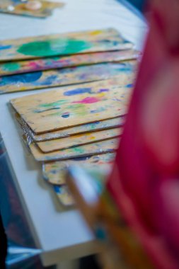 Stüdyoda yağlı boya kalıntıları olan boya paletlerinin yakın çekimi güzel sanatların sevgisi kavramını resmetmek için.