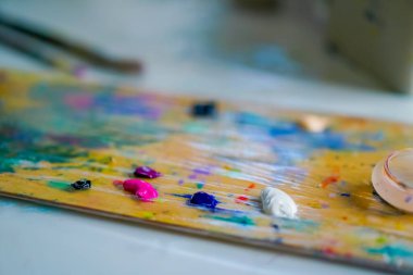 Stüdyoda yağlı boya kalıntıları olan boya paletlerinin yakın çekimi güzel sanatların sevgisi kavramını resmetmek için.