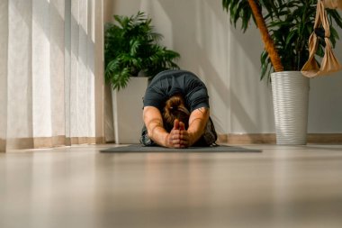 Kollarını ve arkasını kapayarak ayaklarına kapanmış, esnek, aktif bir hobi edinmiş bir adamın...