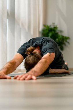 Kollarını ve arkasını kapayarak ayaklarına kapanmış, esnek, aktif bir hobi edinmiş bir adamın...