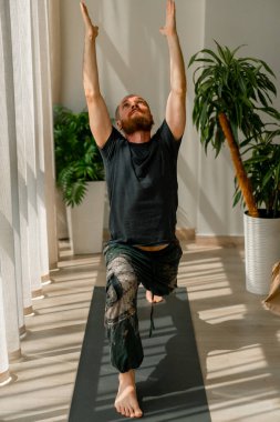 Çetin ceviz adam ellerini kaldırır ve tüm vücudunu esneterek yoga yapar.