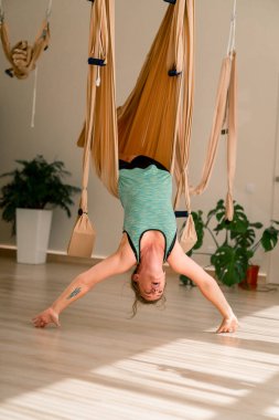 Tombul pozitif kız özel tuvallerde havada baş aşağı asılı duruyor.