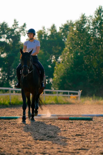 Een Ruiter Gekleed Een Helm Rijdt Haar Mooie Zwarte Paard — Stockfoto