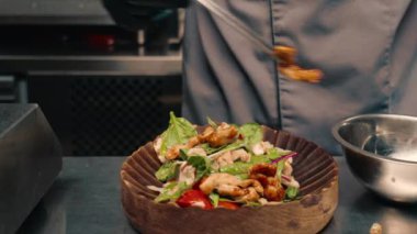 Restoranın şefi taze salata ve tabakta tavuk servis ediyor. Profesyonel Asya mutfağı.