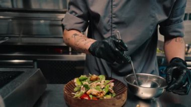 Restoranın şefi taze salata ve tabakta tavuk servis ediyor. Profesyonel Asya mutfağı.