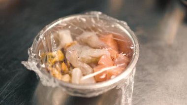 Profesyonel mutfakta pişirmeden önce metal bir kâsede taze çiğ deniz ürünleri yakın plan.