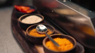 Asya restoranındaki profesyonel bir mutfakta metal tezgahın üzerinde duran doğu baharatlarının yakın plan çekimi.