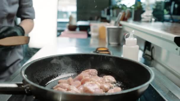 餐馆里的一个专业厨房里的厨师在平底锅里煎多汁的鸡排 — 图库视频影像