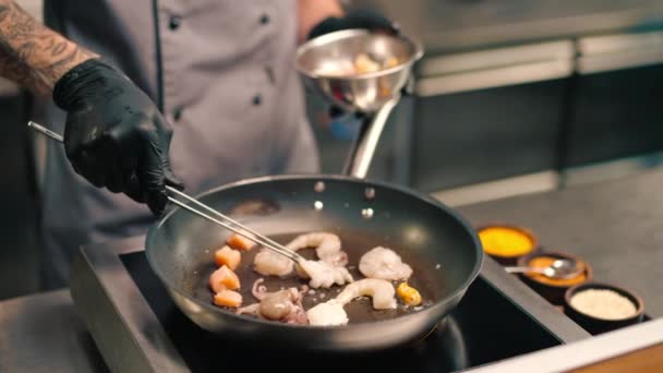 酒店餐厅的专业厨房里 厨师把带有钳子的海鲜放在平底锅里 把它们作为亚洲菜的特写 — 图库视频影像