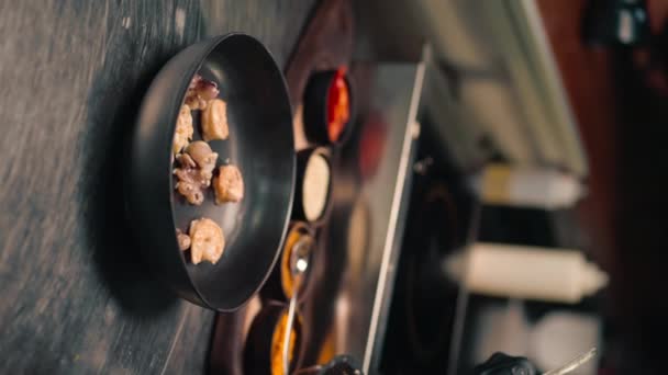 ホテルのレストランの専門のキッチン クローズアップシーフードパン揚げ垂直ビデオエビイカムール貝サーモン スコップ — ストック動画