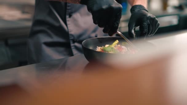 主厨在专业厨房的特写镜头 用钳子加绿菜装饰海鲜清汤 — 图库视频影像