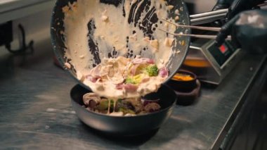 Restoran şefi taze pişmiş leziz deniz ürünleri sote ile kremalı sos servis ediyor. Profesyonel Asya mutfağında.