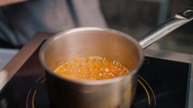 Profesyonel restoran mutfağı şefi baharatlı Tom leziz Asya çorbası hazırlıyor.