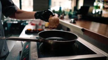 Profesyonel mutfakta kızarmadan önce tereyağlı tavada kurutulmuş derisi olan sulu ördek göğsüne yakın plan.