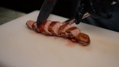 Profesyonel restoran aşçısı Asya mutfağına yakın bıçaklı lezzetli kızarmış ördek göğsü kesiyor.