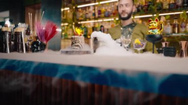 Profesyonel barmen taze alkoliğin yanına içki döker. Lezzetli, sıvı nitrojen. Güzel ve muhteşem bir içki servisi.