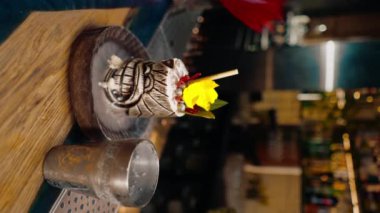 Dikey video taze alkollü kokteyl barın yanında durur. Sıvı nitrojen bardaki içkinin güzel ve etkili bir şekilde yayıldığı yerde.