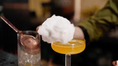 Barmen bardaki ya da restorandaki yakın çekimde bir konuğa taze ve lezzetli bir kokteyl verir.