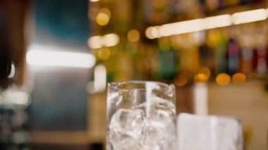 Profesyonel barmen bardaki ölçüm bardağına alkol döker.