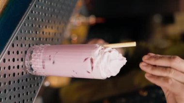 Bir barmenin ya da restoranın hazırladığı yeni hazırlanmış alkollü kokteyli maşayla süslediği dikey video.