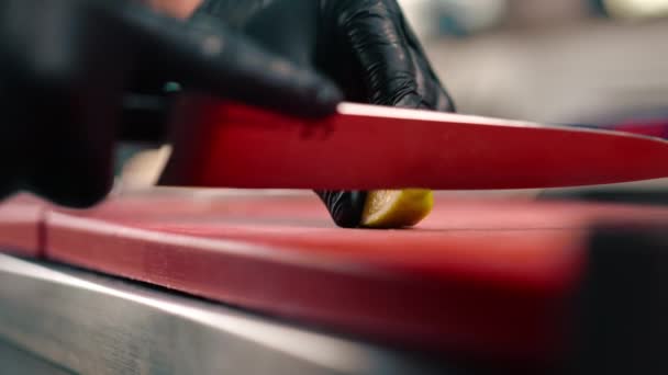 ナイフでレモンを切るブラックグローブのシェフの手のクローズアップ プロのキッチン — ストック動画