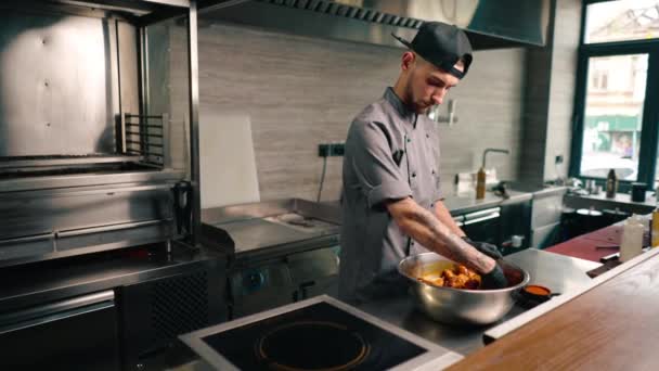 专业餐厅厨房厨师在碗亚洲菜中搅拌带有香料的鸡翅 — 图库视频影像