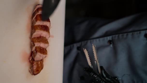 プロのレストランのキッチンシェフは 垂直ビデオを閉じるナイフのアジア料理と美味しいローストアヒルの胸をカット — ストック動画