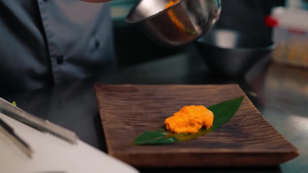 シェフのクローズアップは 料理の美しいプレゼンテーションを提供しています パッションフルーツピューレ プレートアジア料理にスプーン — ストック動画