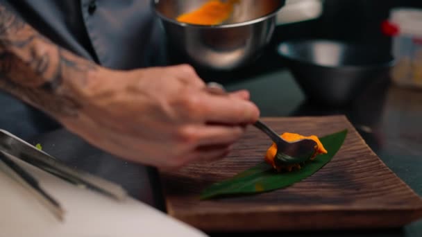 シェフのクローズアップは 料理の美しいプレゼンテーションを提供しています パッションフルーツピューレ プレートアジア料理にスプーン — ストック動画