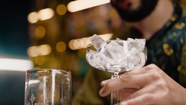 Close Bartender Derrama Cubos Gelo Uma Taça Coquetel Preparação Deliciosos — Vídeo de Stock