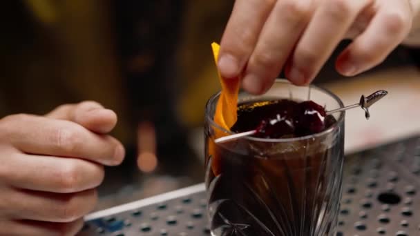Close Barman Přidá Oranžový Klín Čerstvě Vyrobeného Černého Alkoholického Koktejlu — Stock video