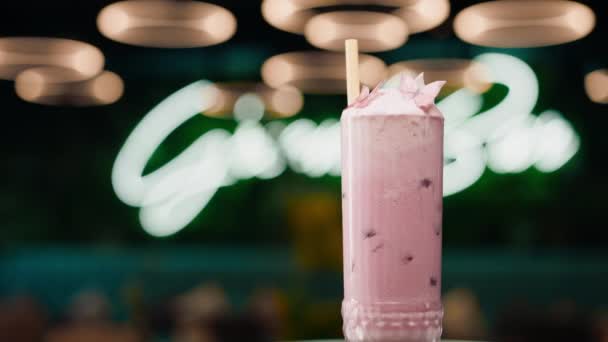バークラブのバーカウンターでクリームが回転する新鮮なピンクのアルコールカクテルを閉じる — ストック動画