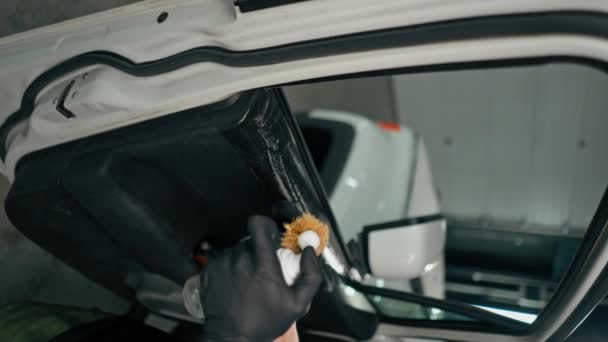 在详细的垂直处理过程中 一名洗车工人在清洗豪华车门卡时使用塑料清洗刷进行的特写 — 图库视频影像