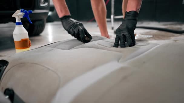 洗车工人在洗车过程中使用真空吸尘器清洁白色汽车座椅的特写镜头 — 图库视频影像