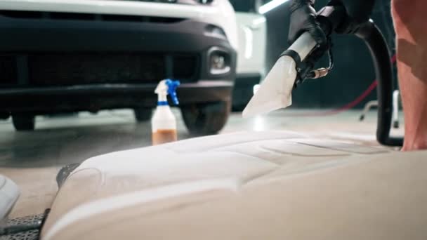 掃除機を使用した洗車作業員のクローズアップにより 白い車のシートを清掃 — ストック動画