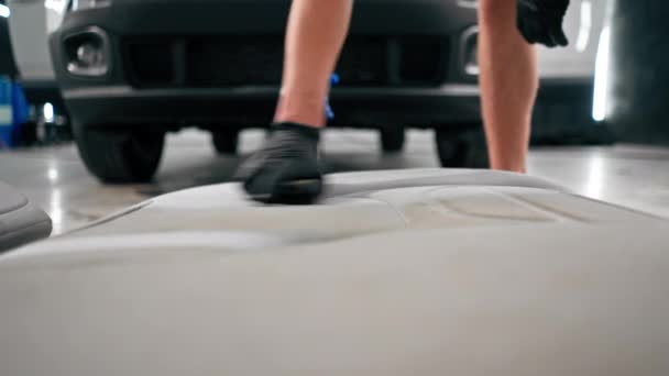 Zbliżenie Pracownika Myjni Samochodowej Używającego Odkurzacza Czyszczenia Białych Siedzeń Samochodowych — Wideo stockowe