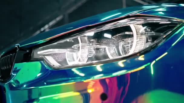 Zbliżenie Przedniego Światła Luksusowego Samochodu Pokrytego Folią Kamelionową Myjni Samochodowej — Wideo stockowe