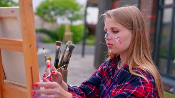 Artista Femenina Enfocada Con Pintura Cara Pintando Cuadro Pie Sobre — Vídeos de Stock